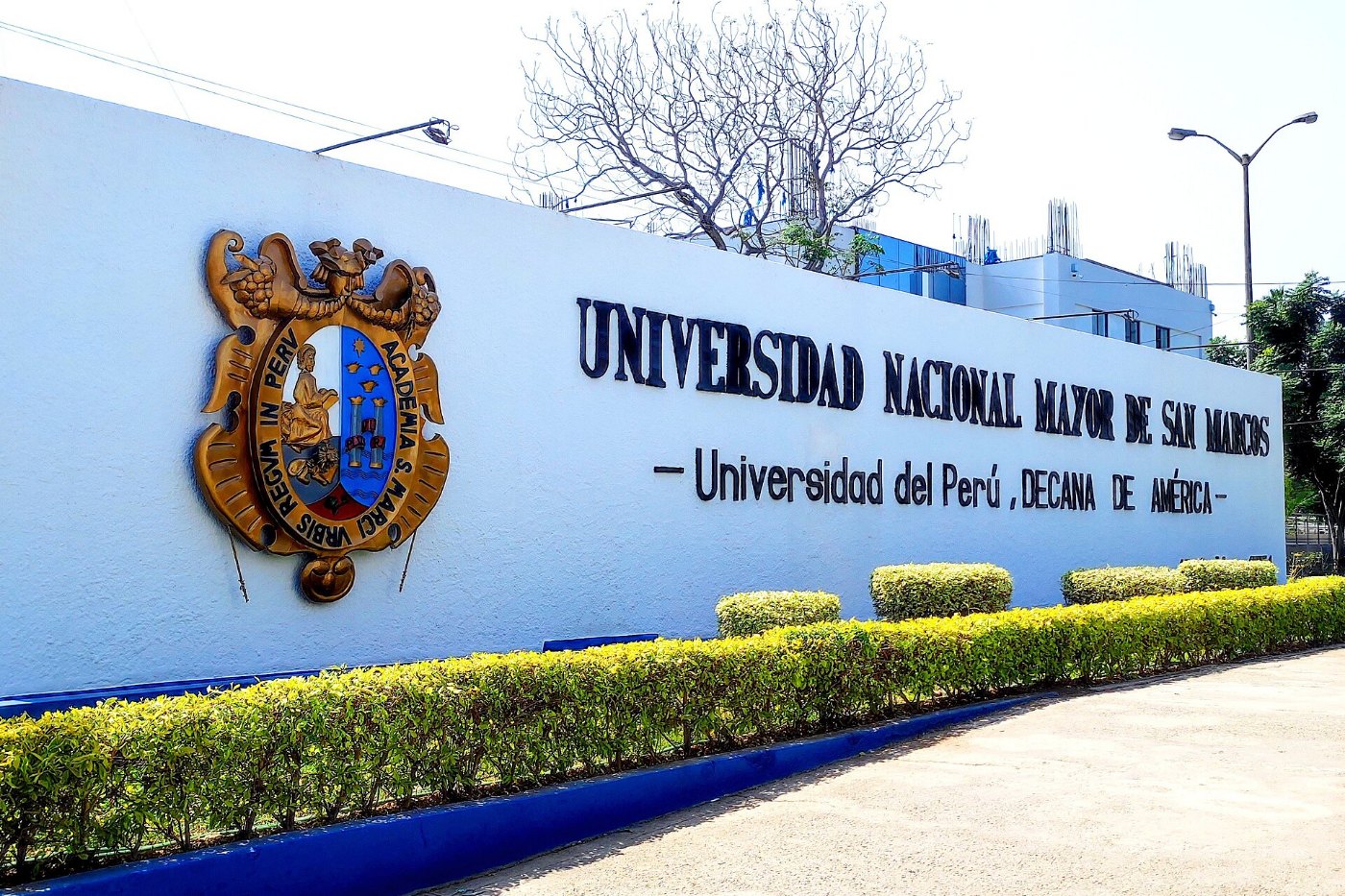 Muro de San Marcos con escudo y el rótulo Universidad del Perú, decana de América